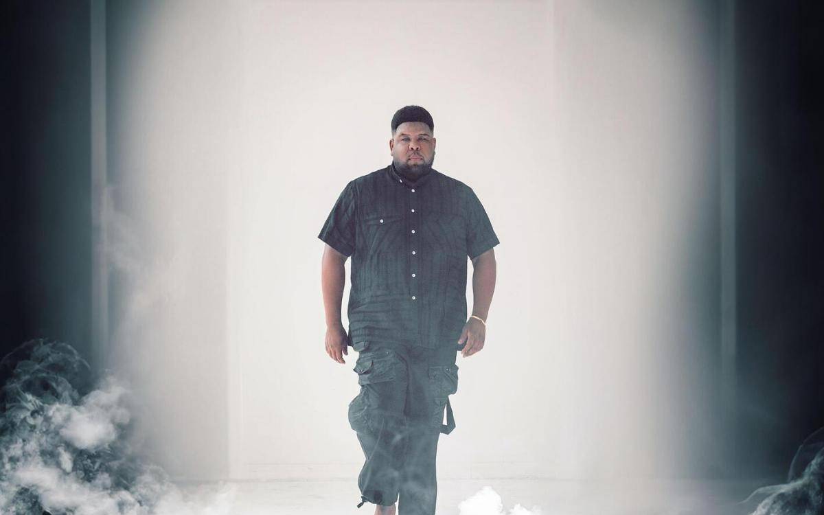 Das Musikcover der Single "Thee Unknown" von Ray Dalton zeigt ihn Barfuß in schwarzer Kleidung in einem weißen Raum mit Rauch.