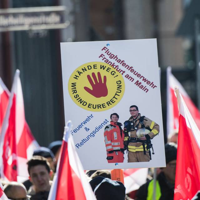 in Plakat "Hände weg! Wir sind Eure Rettung" wird von einem Mitglied der Flughafen Feuerwehr Frankfurt auf einer Demonstration gehalten. Rettungskräfte demonstrieren in der Banken-Metropole für mehr Respekt und gegen Gewalt bei ihren Einsätzen