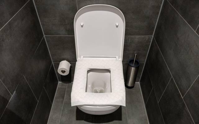 Ein Toilettensitz ist mit Toilettenpapier belegt
