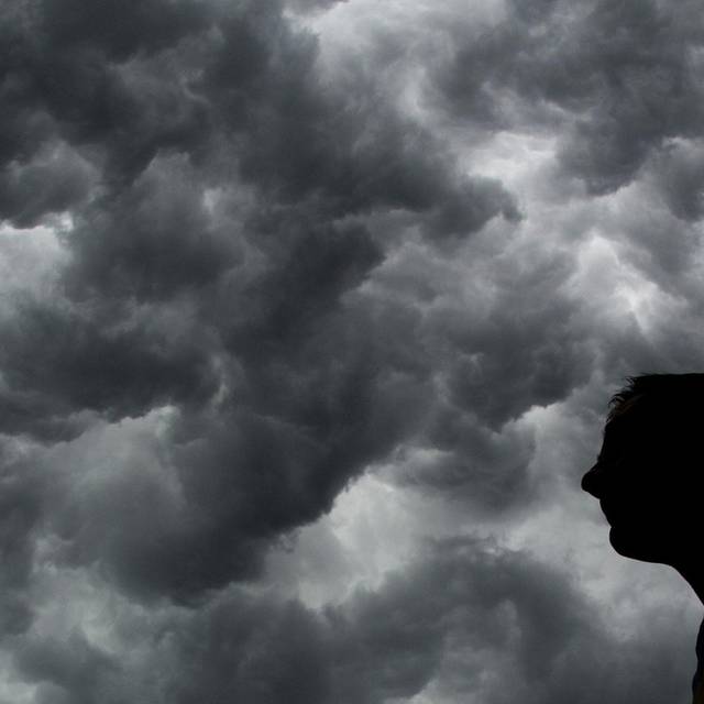 Ein Mann steht unter einem stürmischen Himmel