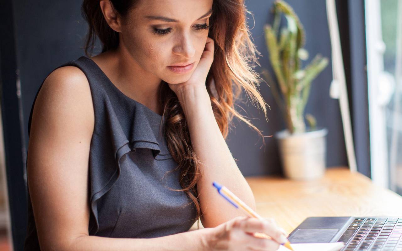 Eine Frau arbeitet in einem Café am Laptop