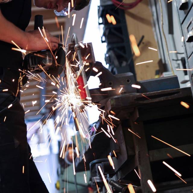 Kunstschmied arbeitet mit einem Winkelschleifer