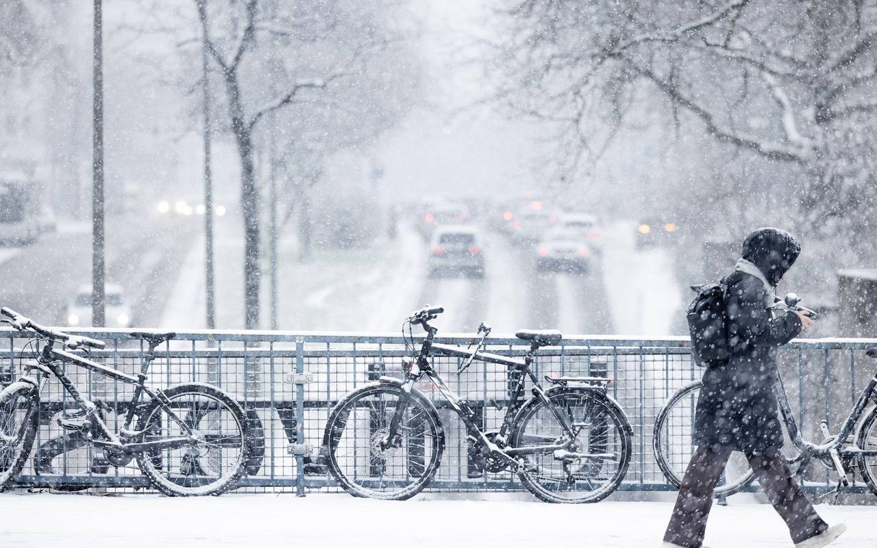 Schneebedeckte Fahrräder im dichten Schneetreiben