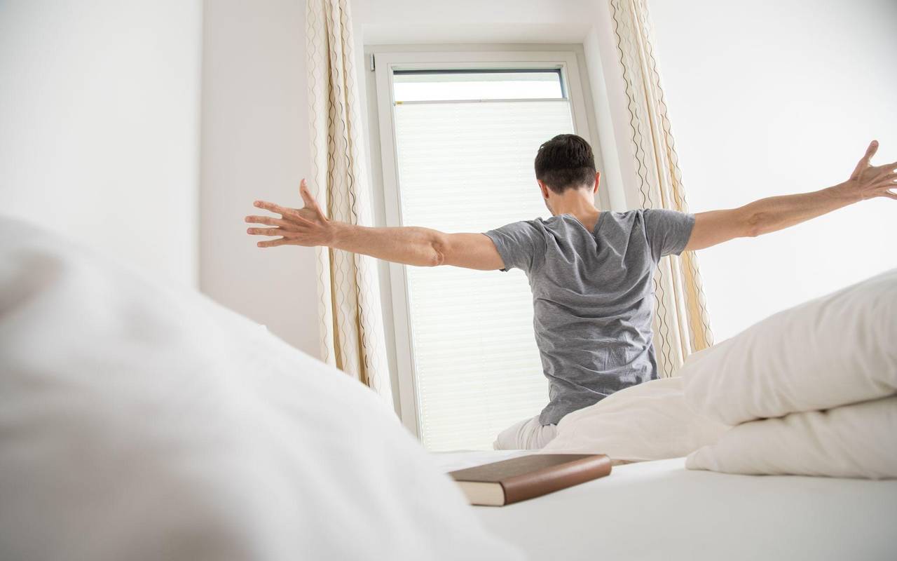 Ein Mann streckt sich am Morgen nach dem Aufwachen