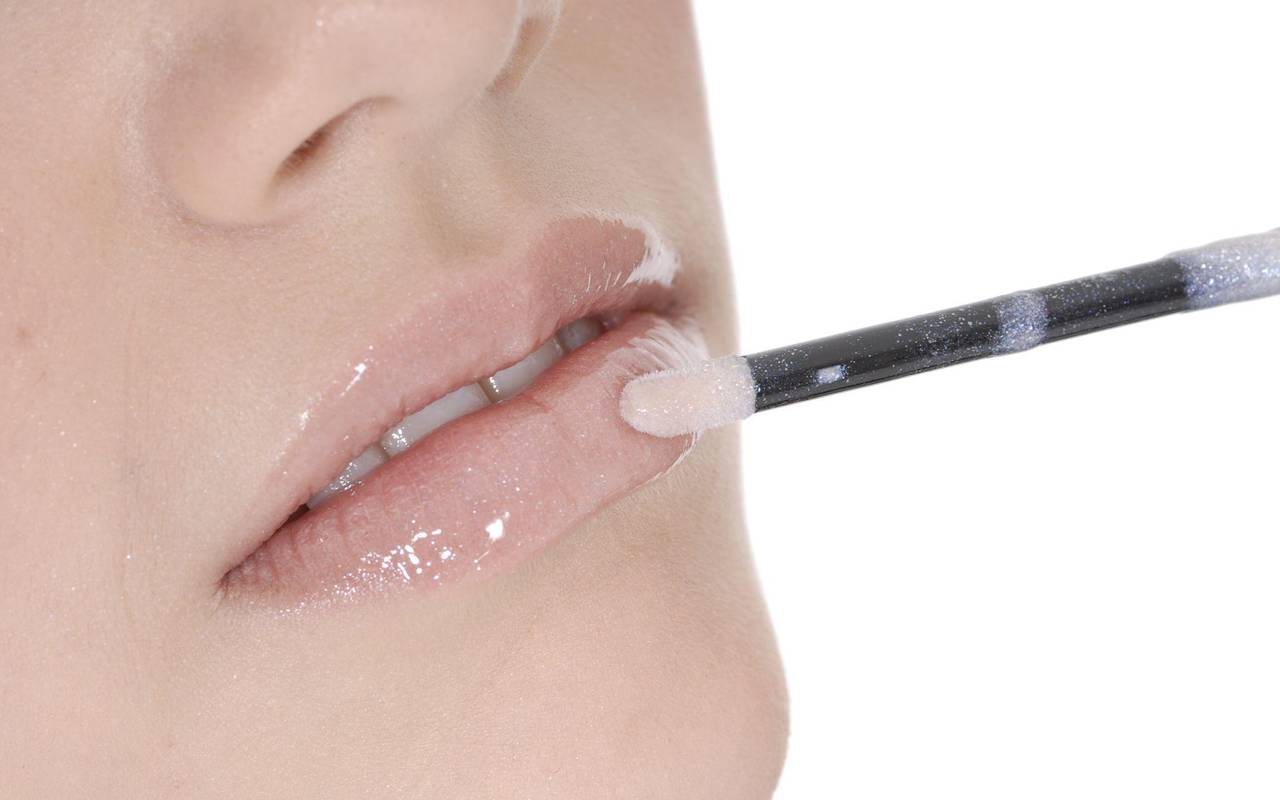 Frau schminkt die Lippen in einem Nude-Ton