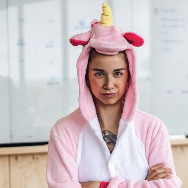 Frau trägt im Büro ein Einhorn-Kostüm