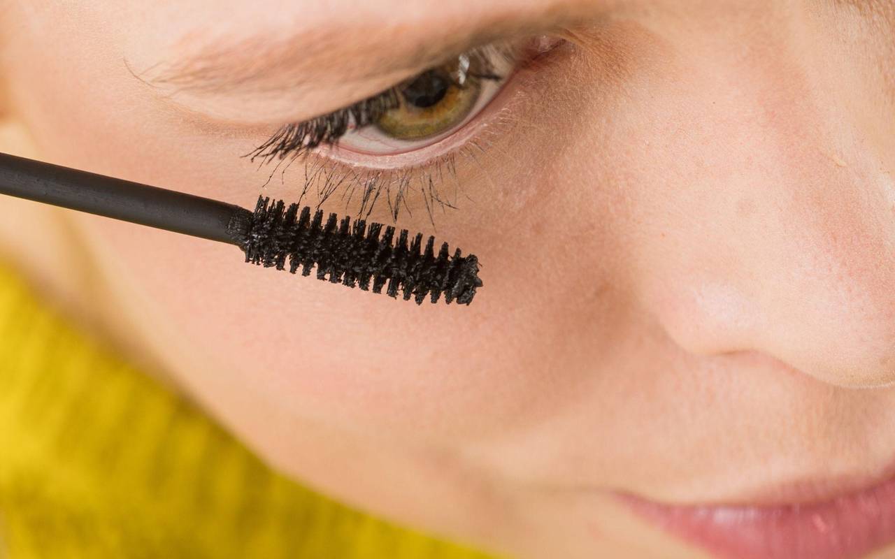 Eine Frau trägt Mascara auf ihre Wimpern auf