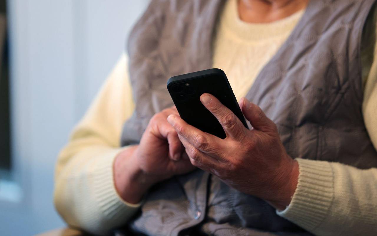 Eine Seniorin schreibt eine Nachricht in ihr Handy