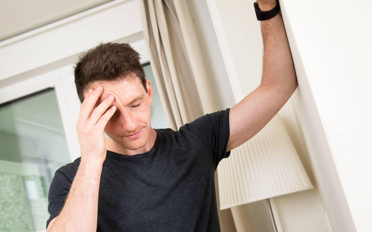 Mann hält sich den schmerzenden Kopf