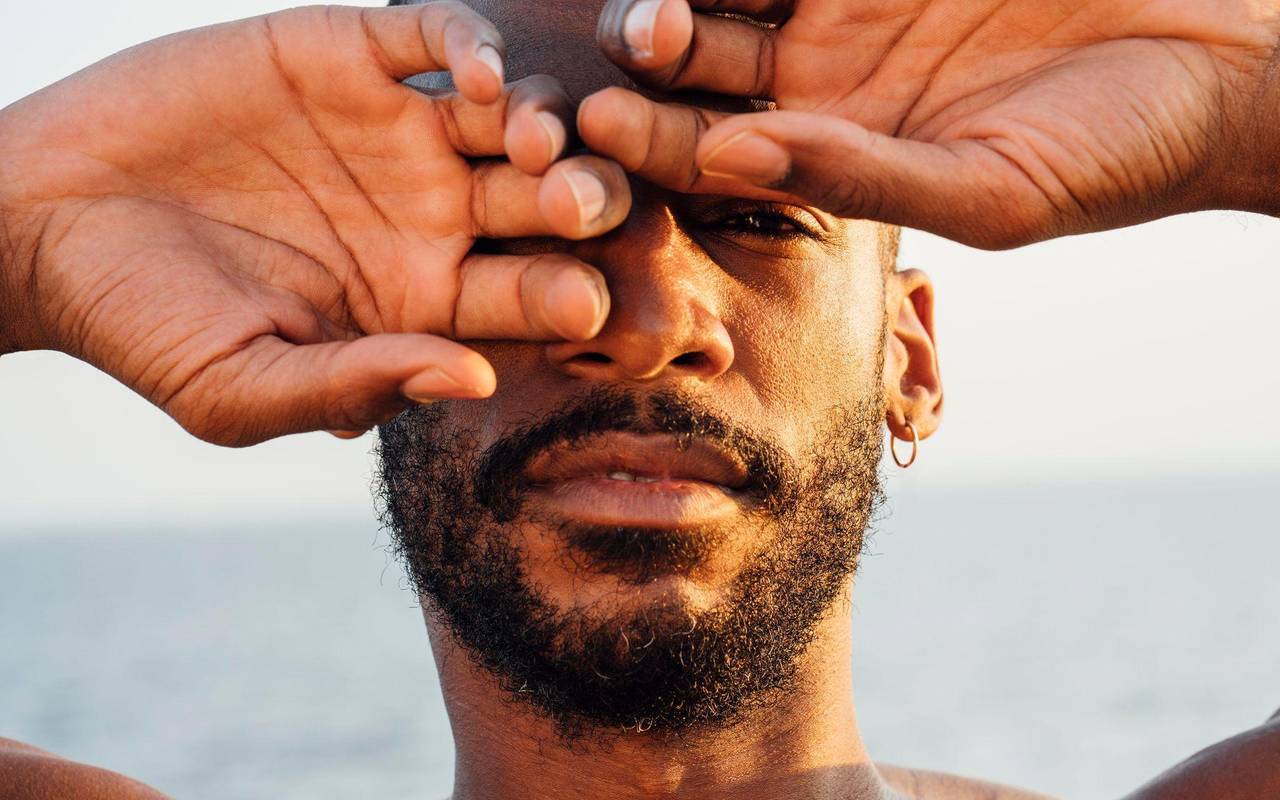 Ein Mann mittleren Alters hält die Hände vors Gesicht