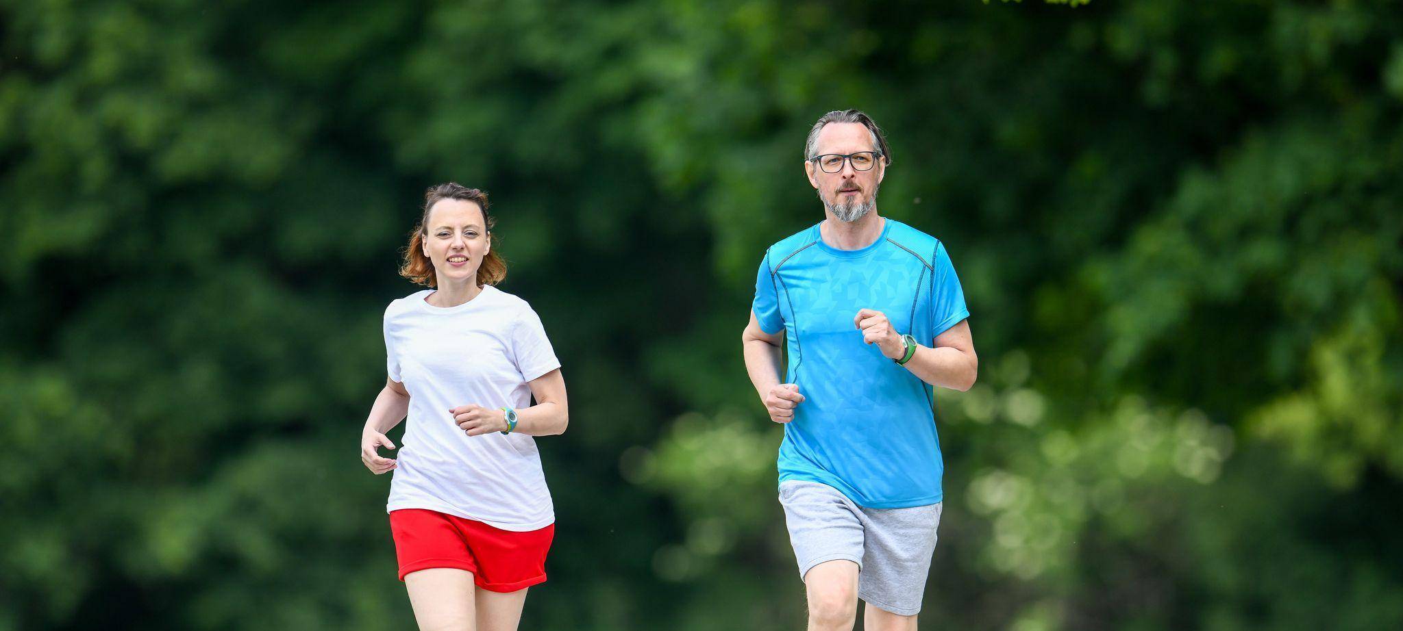Ein Mann und eine Frau joggen gemeinsam im Park