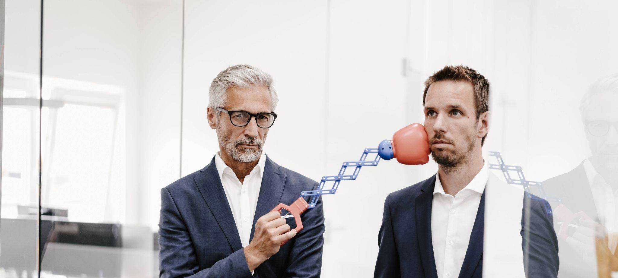 Ein Mann trfft einen Kollegen mit einem Boxspielzeug am Kinn